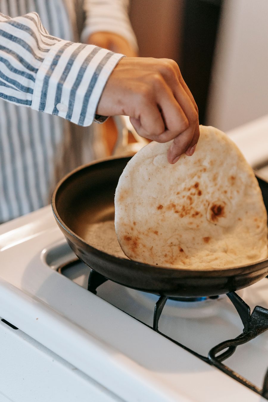 Fresh chapati being cooked in a pan at home