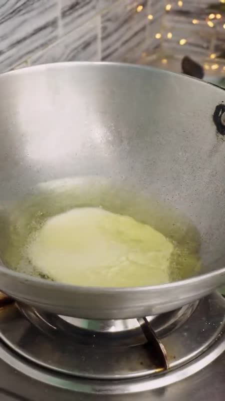 A Rotikaa puri puffing up golden in hot oil